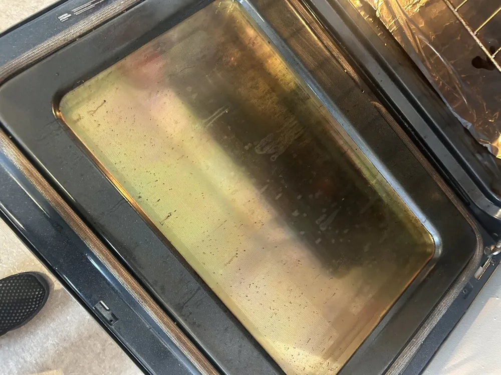 Greasy oven door glass before cleaning