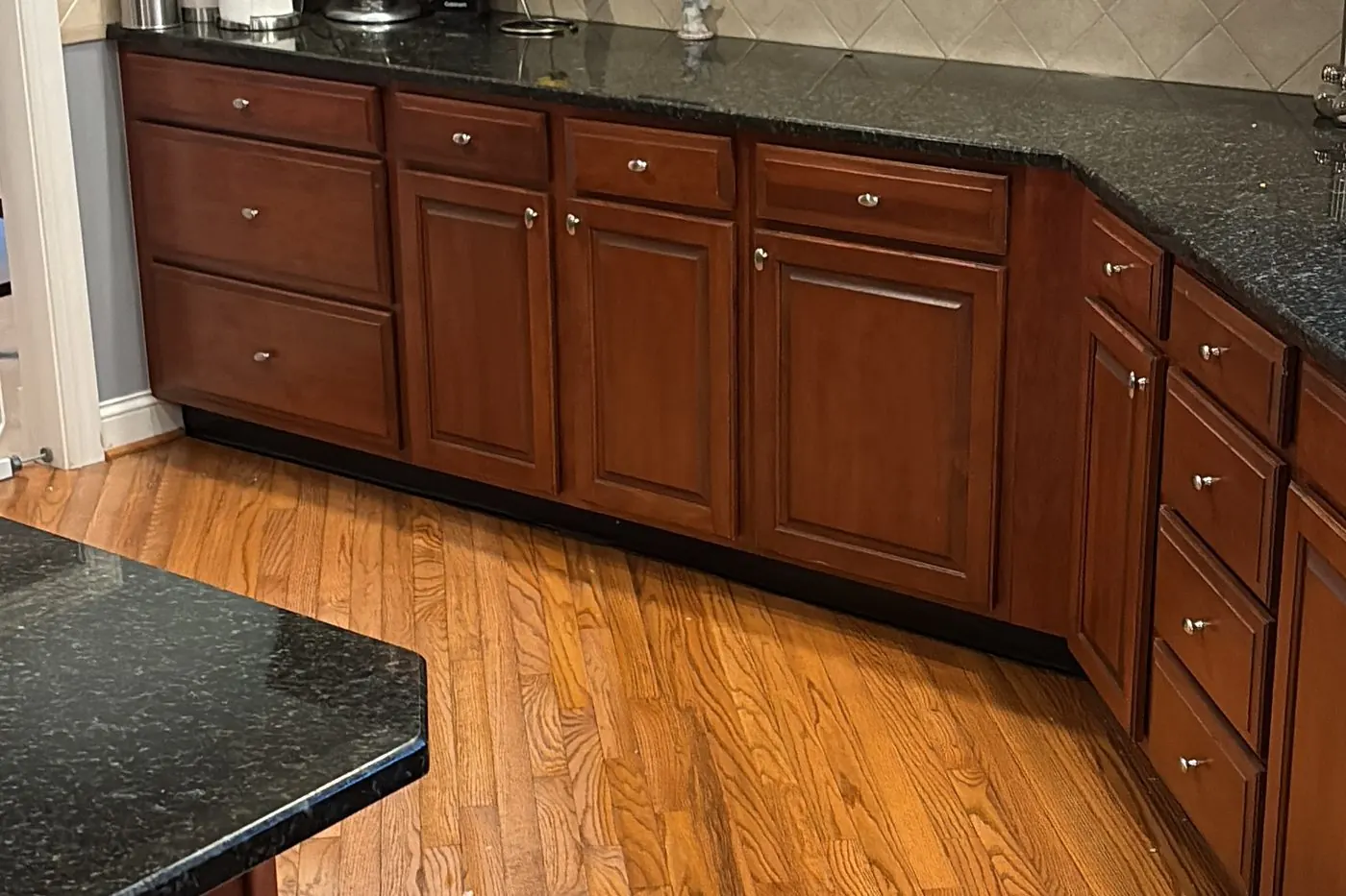 Kitchen with cleaned granite counters and hardwood floor